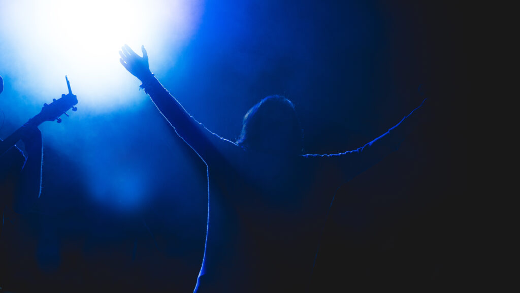 Church leader raising his both hands during concert
